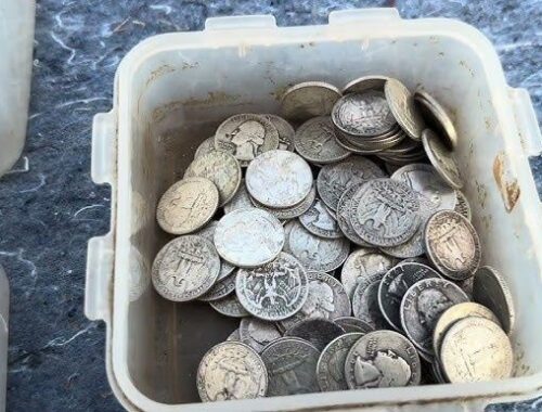 En plastlåda fylld med blandade äldre silverfärgade mynt