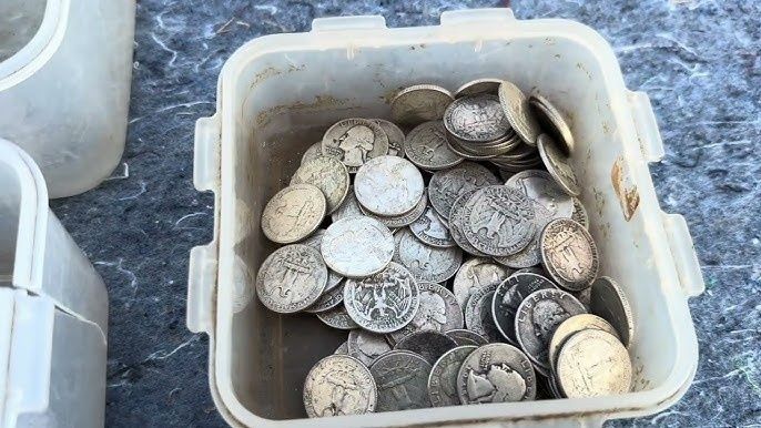 En plastlåda fylld med blandade äldre silverfärgade mynt