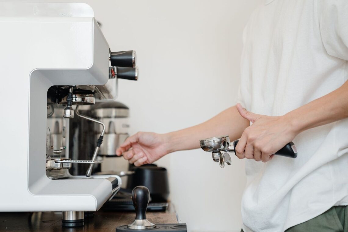 Person arbetar med en espressomaskin med portafilter och verktyg