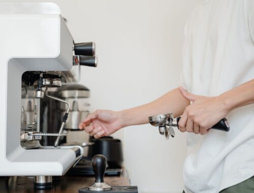 Person arbetar med en espressomaskin med portafilter och verktyg